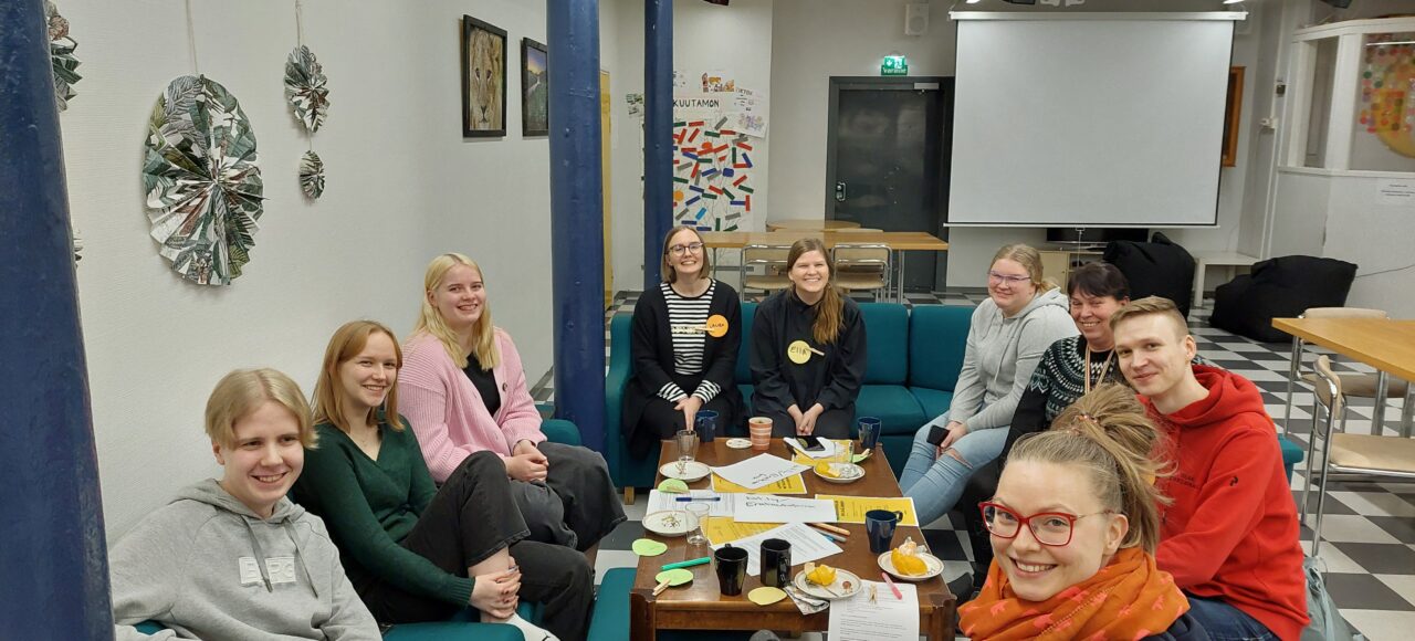 Kuvassa nuoria ja aikuisia keskustelemassa yhdessä.