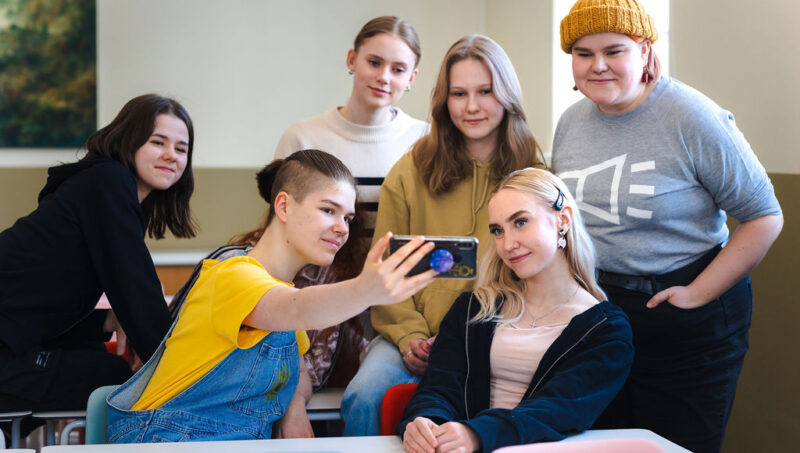 Kuvassa nuoret ottavat puhelimella ryhmäkuvaa.